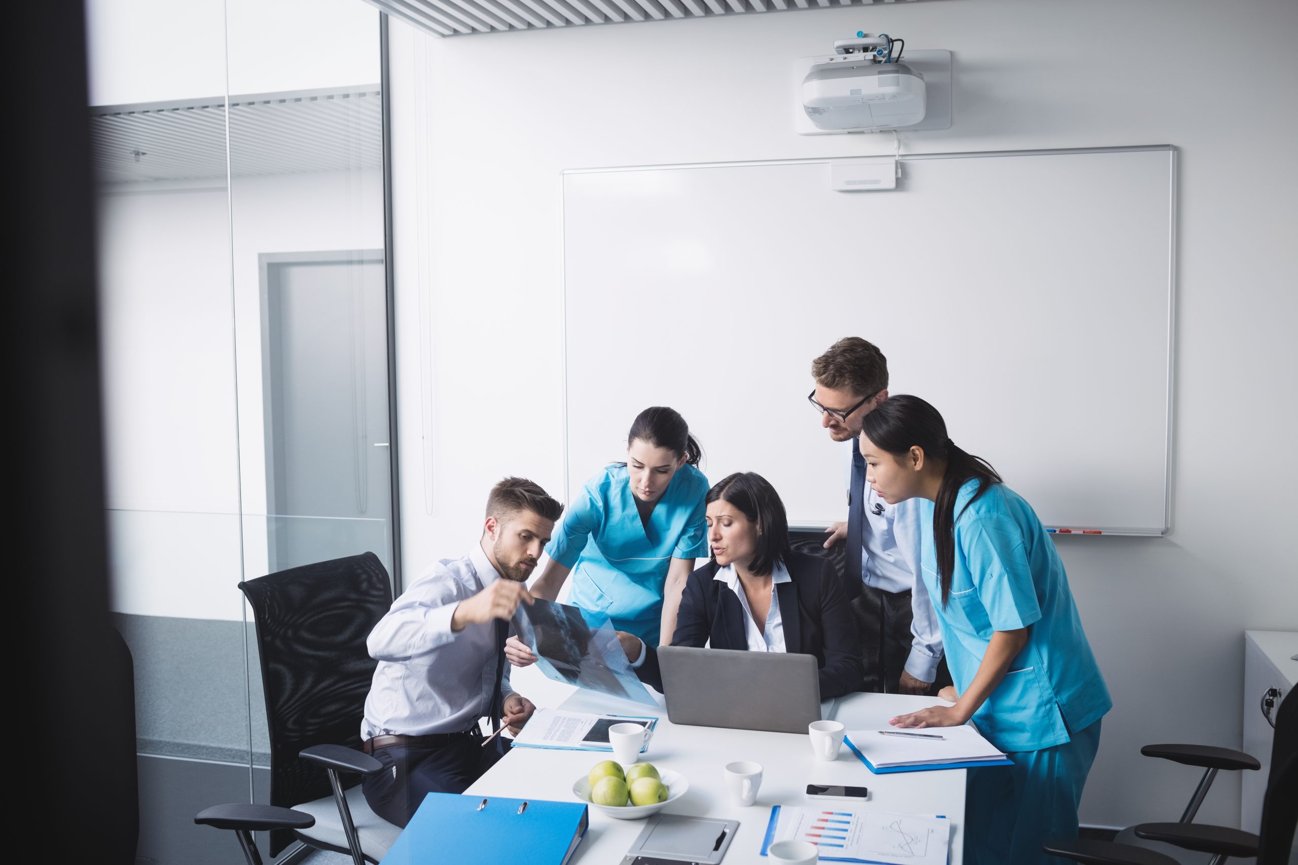 Medical team examining an x-ray report in conference room